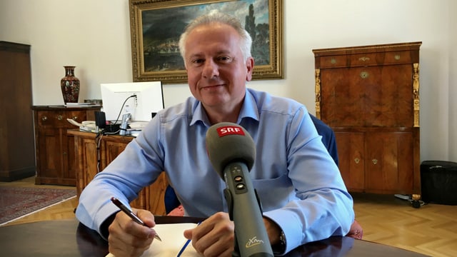 Stadtpräsident an einem Tisch mit SRF-Mikrofon. Stadtpräsident an einem Tisch mit SRF-Mikrofon.