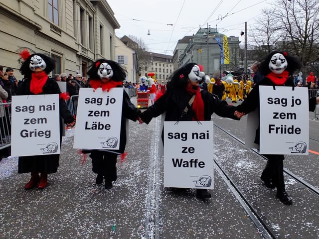 Vier Larven mit Polit-Slogans.