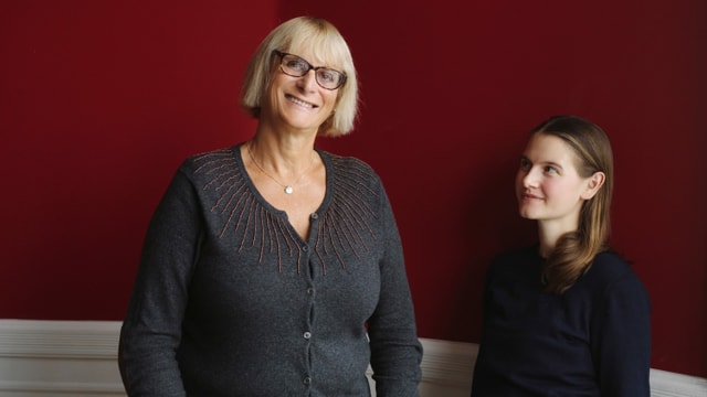 Eine junge Frau steht neben einer älteren, sehr grossen Frau. Eine junge Frau steht neben einer älteren, sehr grossen Frau.