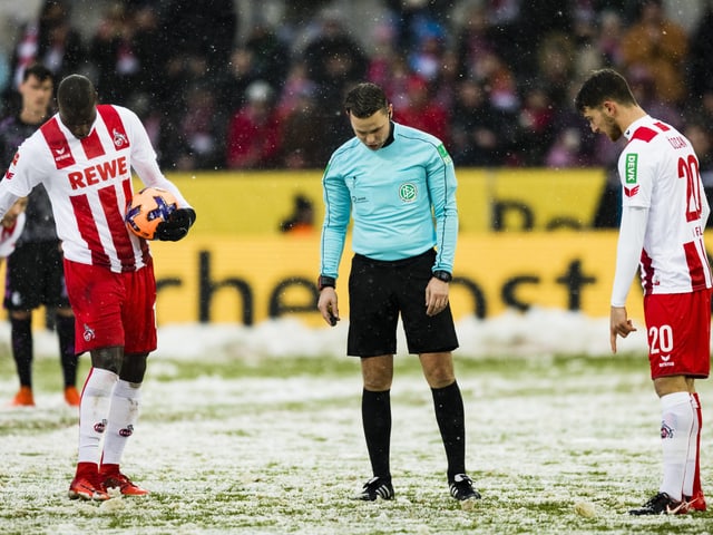 Kölner Spieler und der Schiedsrichter suchen den Penaltypunkt