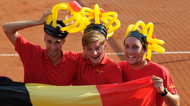 Ruben Bemelmans, David Goffin und Steve Darcis feiern mit lustigen Hüten und belgischer Fahne. 