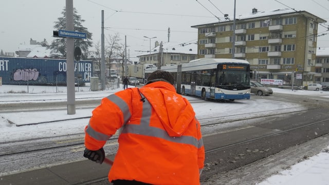 Ein Angestellter der Stadt Zürich räumt den Schnee auf der Strasse weg Ein Angestellter der Stadt Zürich räumt den Schnee auf der Strasse weg