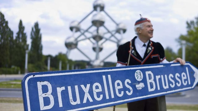 Gestellte Aufnahme: Schweizer in traditioneller Kleidung vor dem Atomium. Gestellte Aufnahme: Schweizer in traditioneller Kleidung vor dem Atomium.