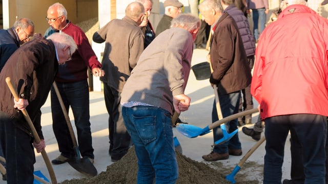 Sänger schaufeln Sand von einem Haufen. Sänger schaufeln Sand von einem Haufen.