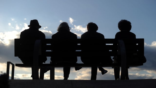 Vier Rentner auf einer Bank, von hinten