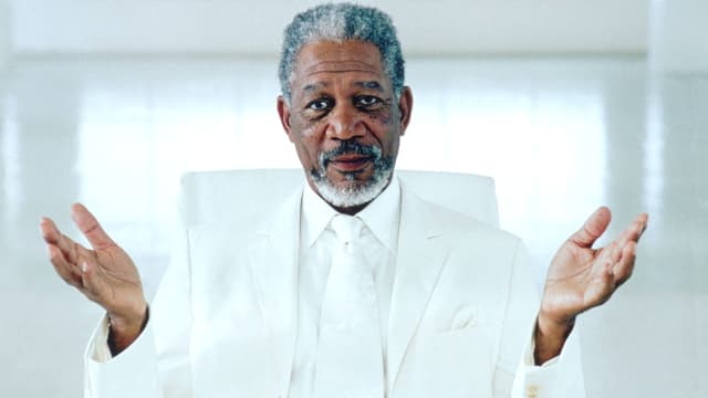 Morgan Freeman in weissem Anzug und mit geöffneten Händen. Morgan Freeman in weissem Anzug und mit geöffneten Händen.