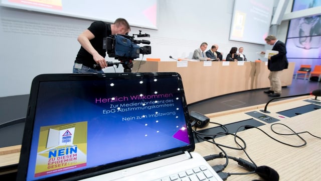PC an einer Medienkonferenz mit dem Logo der Gegner. PC an einer Medienkonferenz mit dem Logo der Gegner.