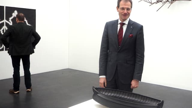 Ein Mann steht hinter einer Bootskulptur. Ein Mann steht hinter einer Bootskulptur.