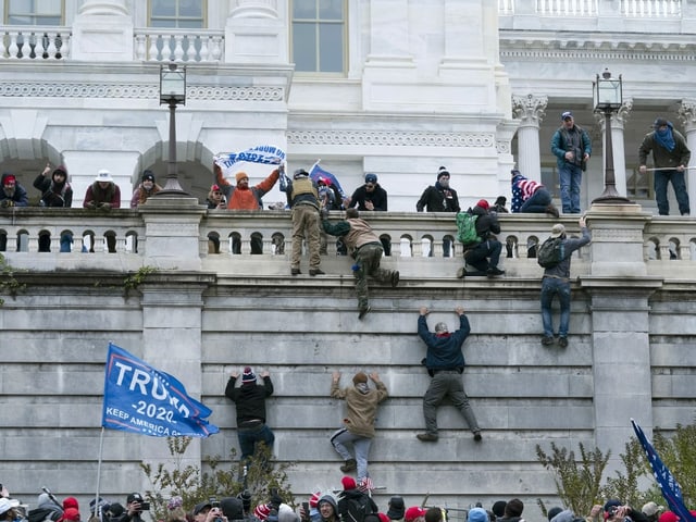 Protestierende klettern Mauern hoch