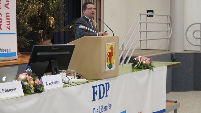 Mann an Rednerpult, Logo der FDP daran. Mann an Rednerpult, Logo der FDP daran.