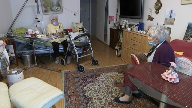 Zwei Frauen in einem Altersheimzimmer.