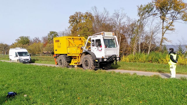 Weisses fahrzeug mit gelbem Aufbau auf schmalem Weg. Weisses fahrzeug mit gelbem Aufbau auf schmalem Weg.