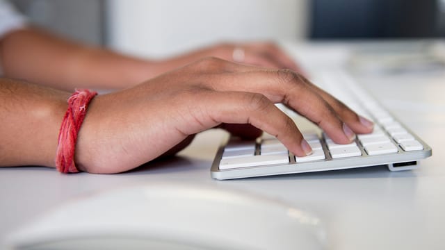 Schreibender Mensch am Computer.