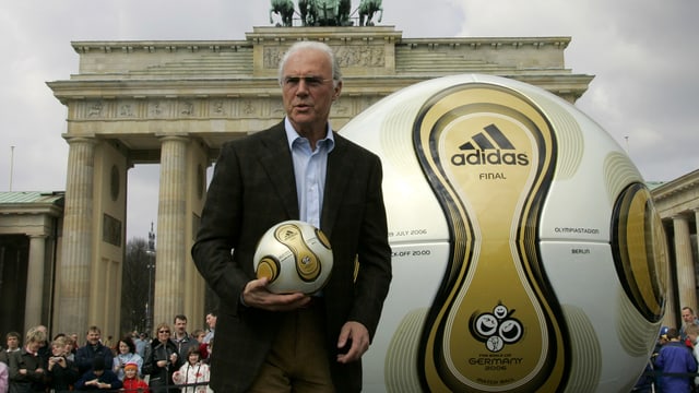 Beckenbauer mit einem Ball vor dem Brandenburger Tor. Beckenbauer mit einem Ball vor dem Brandenburger Tor.
