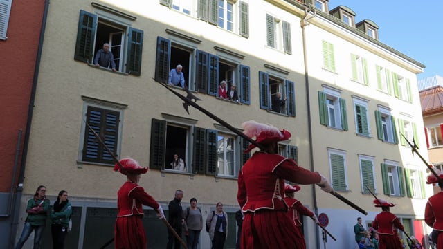 Menschen schauen aus fenstern dem Umzug zu. Menschen schauen aus fenstern dem Umzug zu.