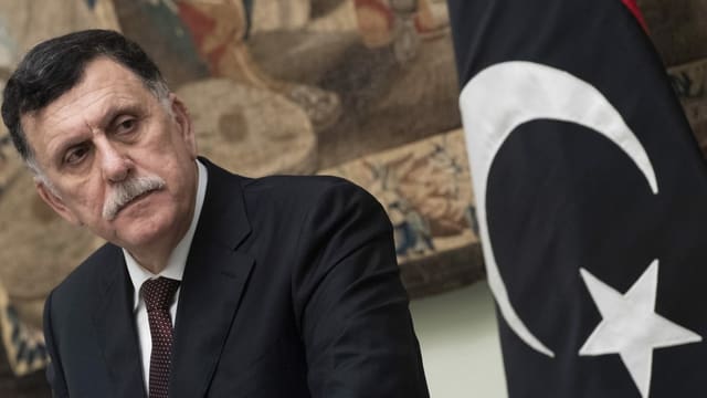Premier Fajes al-Sarradsch neben einer libyschen Flagge Premier Fajes al-Sarradsch neben einer libyschen Flagge
