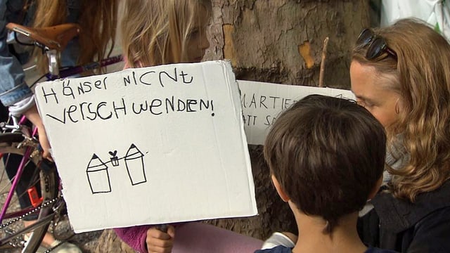 Protestierende mit einem Plakat: Häuser nicht verschwenden. Protestierende mit einem Plakat: Häuser nicht verschwenden.