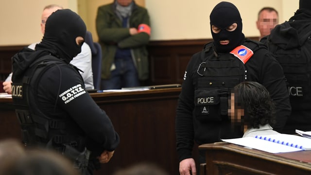 Der Hauptangeklagte im Gerichtssaal, flankiert von zwei vermummten Polizisten. (reuters) Der Hauptangeklagte im Gerichtssaal, flankiert von zwei vermummten Polizisten. (reuters)