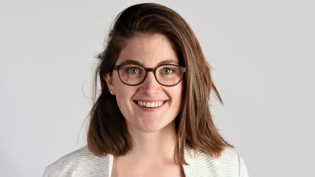 eine junge Frau mit Brille lächelt in die Kamera eine junge Frau mit Brille lächelt in die Kamera