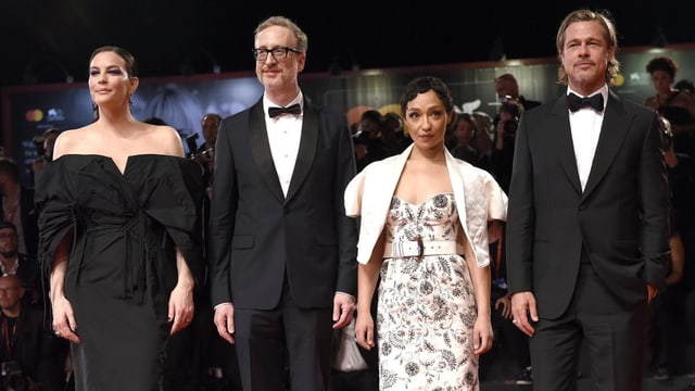 Der elegant angezogene Cast in Kleid und Anzug posiert vor der Kamera. Der elegant angezogene Cast in Kleid und Anzug posiert vor der Kamera.