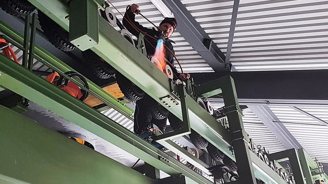 Mann klettert über Metallgerüst mit Tragseilen. Mann klettert über Metallgerüst mit Tragseilen.