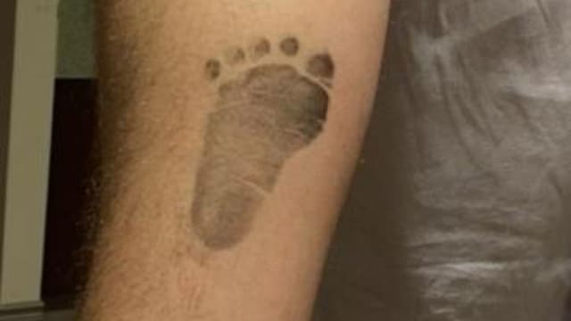 Chris O'Neill mit Babyfuss-Abdruck auf seinem Arm. Chris O'Neill mit Babyfuss-Abdruck auf seinem Arm.