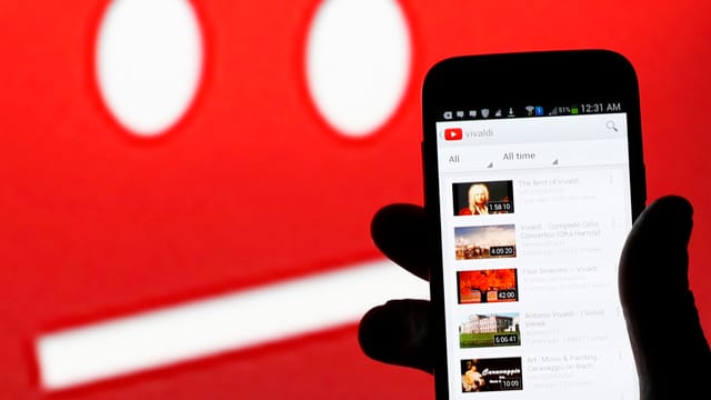 Jemand hält ein Smartphone mit Youtube-App in der Hand. Jemand hält ein Smartphone mit Youtube-App in der Hand.