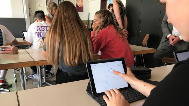 Eine Jugendliche schaut auf ein iPad. Eine Jugendliche schaut auf ein iPad.