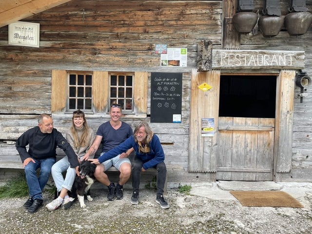 Das Team des Alprestaurants: Jenni Stooss (2. von links) und Nikos Karpathakis (3. von links) kümmern sich gemeinsam um das Restaurant und die Gästeunterkunft auf der Alp Morgeten. Koch Willi Neuenschwander (links) verköstigt die Gäste. Auch auf dem Bild: Hündin Luna, mit der Ralph Wicki schon ausgiebig gespielt hat.