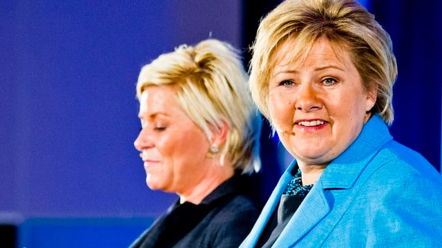 Erna Solberg, rechts, und Siv Jensen nebeneinander an einem Rednerpult. Erna Solberg, rechts, und Siv Jensen nebeneinander an einem Rednerpult.