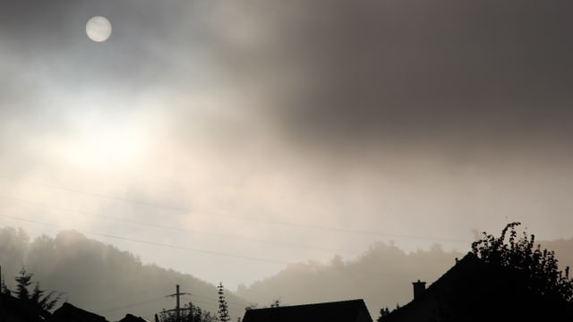 Über den Dächern und dem Wald von Bubendorf wabern Nebelschwaden, durch die sich die Sonne drückt. Über den Dächern und dem Wald von Bubendorf wabern Nebelschwaden, durch die sich die Sonne drückt.