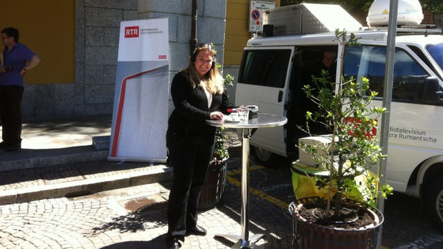 La redactura regiunala Anna Caprez tar la glieud, avant il bus da RTR. La redactura regiunala Anna Caprez tar la glieud, avant il bus da RTR.