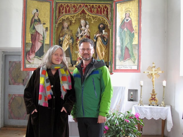 Eine Frau und ein Mann vor dem Altarbild in einer Kapelle Eine Frau und ein Mann vor dem Altarbild in einer Kapelle