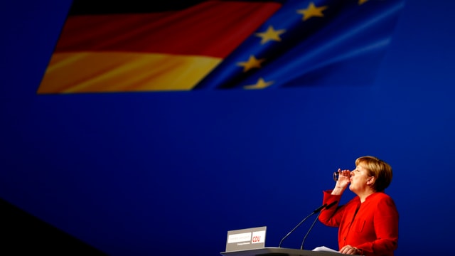 Merkel am Rednerpult, sie trinkt aus einem Glas Wasser. Merkel am Rednerpult, sie trinkt aus einem Glas Wasser.