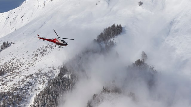 Ein Helikopter überwacht eine künstlich ausgelöste Lawine in der Nähe von Sion