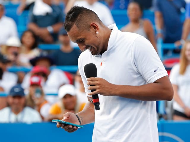 Nick Kyrgios tippt auf seinem Handy. Nick Kyrgios tippt auf seinem Handy.