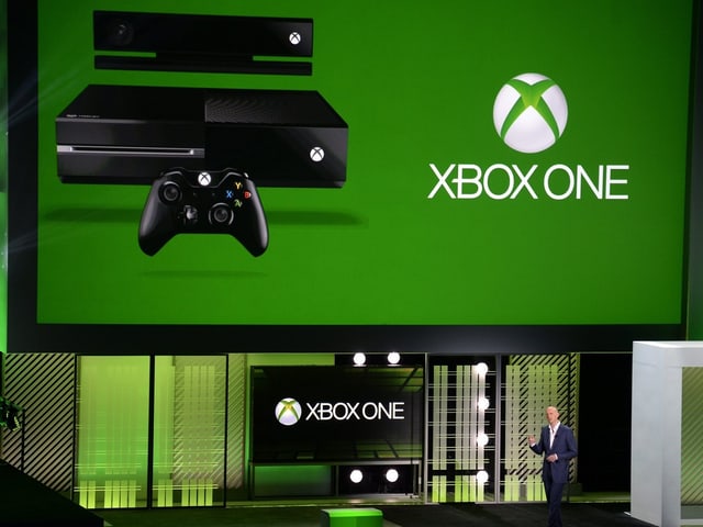 Phil Harrison vor einer grünen Xbox One Folie. Phil Harrison vor einer grünen Xbox One Folie.