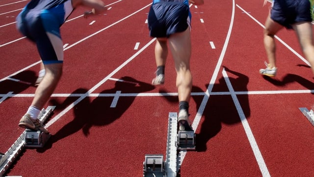100-Meter-Läufer beim Start auf roten Trainingsbahnen 100-Meter-Läufer beim Start auf roten Trainingsbahnen