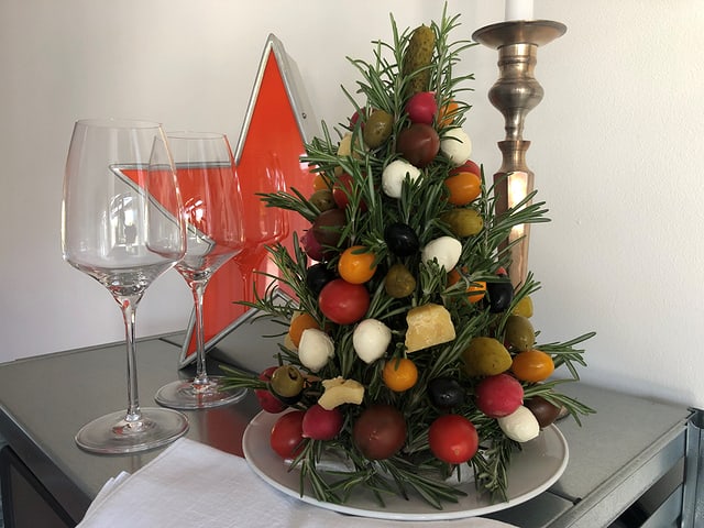 Ein Weihnachtsbaum zum Essen, die Kugeln sind aus Oliven, Cherry-Tomaten, Mozzarella-Perlen, Radieschen Ein Weihnachtsbaum zum Essen, die Kugeln sind aus Oliven, Cherry-Tomaten, Mozzarella-Perlen, Radieschen