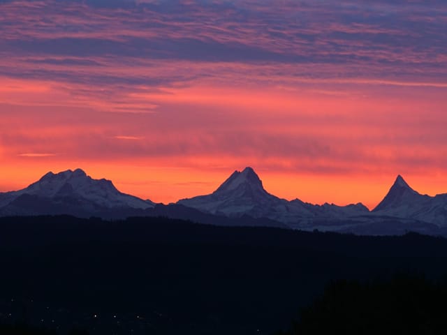 Rosa bis violetter Himmel über Bergen