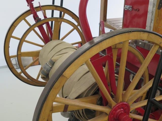 Hinterachse des alten Feuerwehrautos mit Holzrädern und Schläuchen