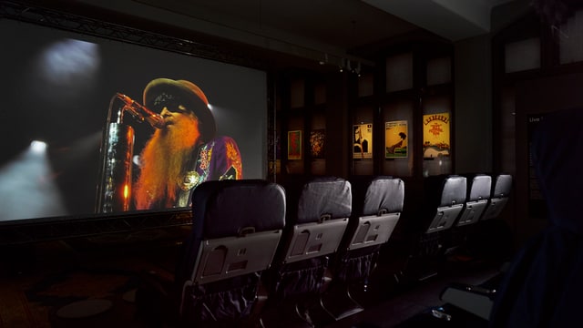 In einem kleinen Kino läuft auf einer Leinwand ein Film In einem kleinen Kino läuft auf einer Leinwand ein Film