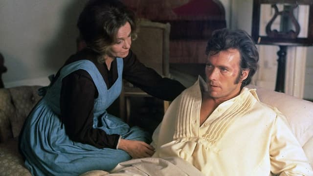 Eine Frau pflegt einen verwundeten Soldaten, der im Bett liegt. Eine Frau pflegt einen verwundeten Soldaten, der im Bett liegt.