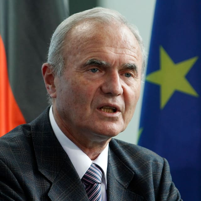 Otmar Issing spricht an einer Konferenz vor einer Deutschland- und einer Europa-Fahne. Otmar Issing spricht an einer Konferenz vor einer Deutschland- und einer Europa-Fahne.