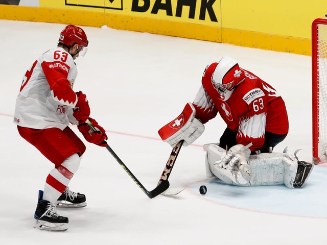 Russlands Jewgeni Dadonow gegen Schweiz-Goalie Leonardo Genoni. Russlands Jewgeni Dadonow gegen Schweiz-Goalie Leonardo Genoni.