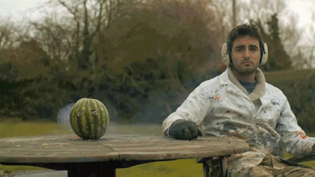 Eine Wassermelone explodiert rückwärts. Ein Mann sitzt traurig daneben. Eine Wassermelone explodiert rückwärts. Ein Mann sitzt traurig daneben.