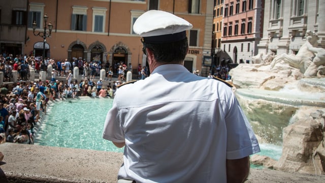 Ein Polizist schaut auf den Trevi-Brunnen. Ein Polizist schaut auf den Trevi-Brunnen.