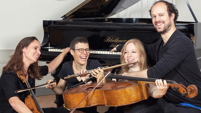 Drei junge Musikerinnen und ein Musiker mit ihren Instrumenten vor einem Flügel. Drei junge Musikerinnen und ein Musiker mit ihren Instrumenten vor einem Flügel.