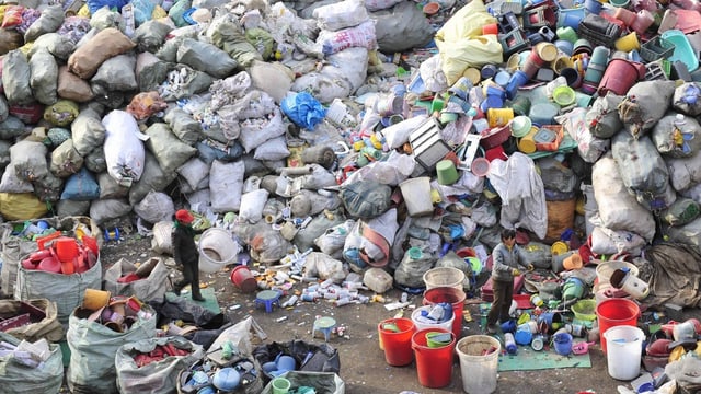 Riesehnaufen an Plastikgegenständen, ein Mann marschiert hindurch. Riesehnaufen an Plastikgegenständen, ein Mann marschiert hindurch.
