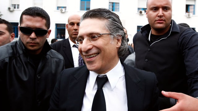 Karoui umringt von Leibwächtern. Karoui umringt von Leibwächtern.